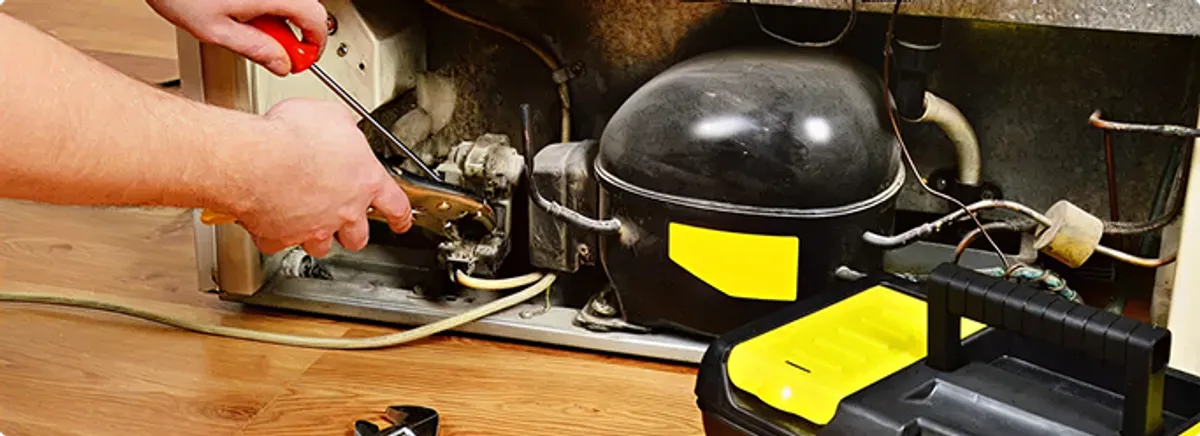 Refrigerator repair technician fixing the compressor and wiring in Palmetto, FL