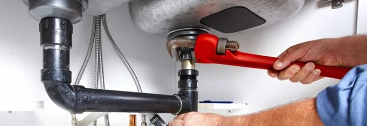 Garbage disposal repair technician tightening the sink drain and disposal connection in Sarasota, FL