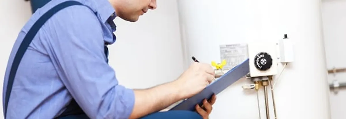 Water heater repair technician inspecting the unit and recording service notes in Sarasota, FL